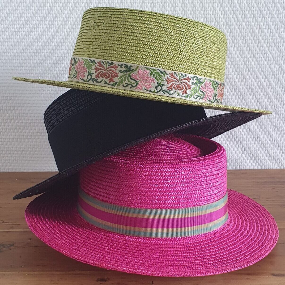 pile de chapeaux de paille canotier vert noir rose