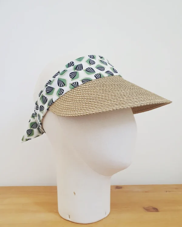 Visière en paille taupe avec bandeau en tissus blanc vert et noir sur tête en tissus